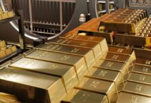 Stacks of gold bullion bars inside bank vault.
