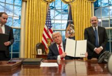 President Trump signs an Executive Order in the White House Oval Office.