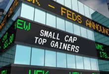 Small cap top gainers on building ticker tape screen.
