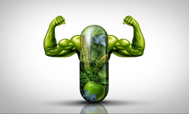 Green plant based foods capsule with arms flexing.
