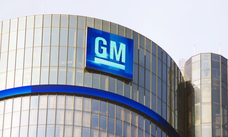 The GM logo displayed on the glass exterior of General Motors' headquarters building.