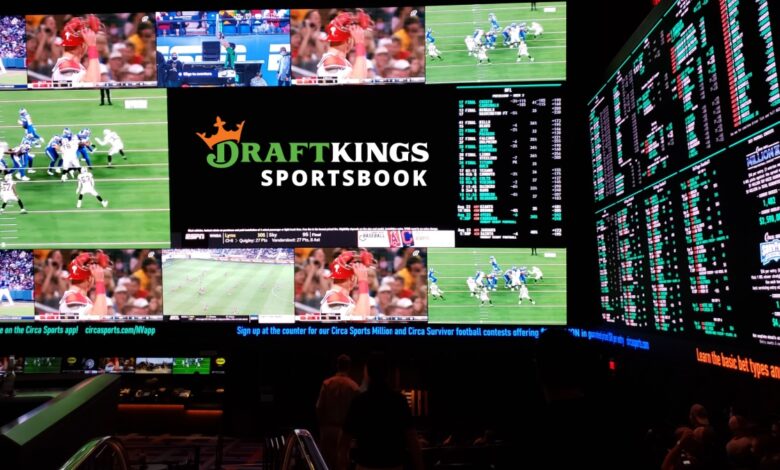 DraftKings Sportsbook venue with large screens showing live sports games and betting odds, highlighting the growing popularity of sports betting.