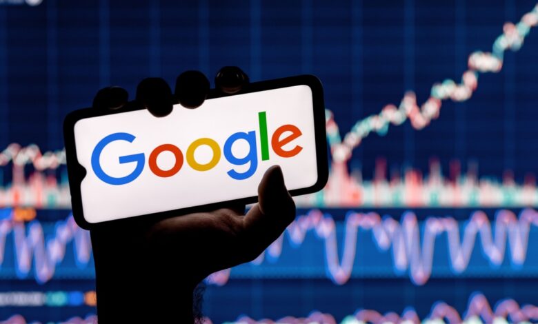 Google logo on smartphone with rising stock chart in the background.