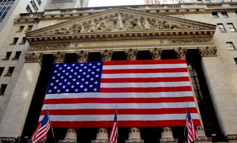 Large American flag hangs in front of the New York Stock Exchange building.