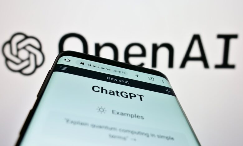 A smartphone screen displaying the ChatGPT interface at chat.openai.com, with the OpenAI logo and name blurred in the background.
