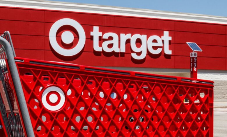 Target retail store exterior with bold red branding and shopping cart in foreground, representing major American big-box retail chain and consumer shopping experience.