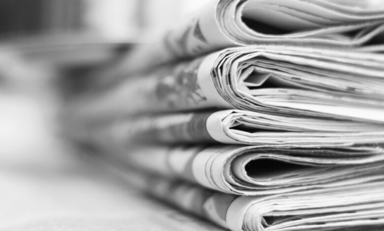 Stack of newspapers in black and white.
