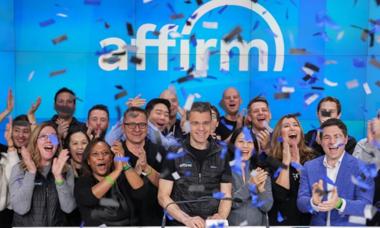 A group of Affirm Holdings management and investors cheering while ringing the NASDAQ opening bell, with confetti steaming down from above.