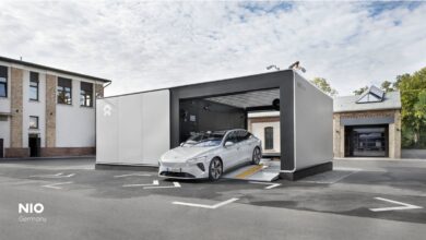 A silver electric vehicle drives out of a NIO Power charging station in Germany.