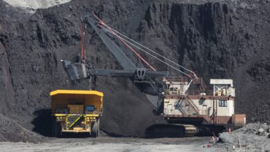 Peabody Energy coal mining excavator dumps freshly mined coal into the back of an extra large yellow haul truck.